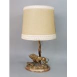 Gilt cast metal figural table lamp depicting a rampant lion over prey, the column in the form of a