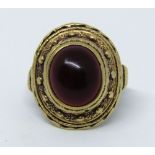 Yellow metal ring set with a cabochon garnet and with beaded decoration, in the Byzantine style,