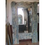 An unusual freestanding or wall mirror, the substantial frame with painted and later distressed