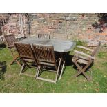 A contemporary weathered hardwood garden table of rectangular form with canted corners and slatted