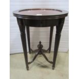 An oval hardwood occasional table raised on turned and fluted supports, 47cm max