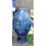 A contemporary blue glazed egg shaped water feature and low stand