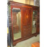 A good quality inlaid Edwardian mahogany triple compactum wardrobe, the central section enclosed