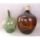 Two large glass carboys one in amber the other in green , the largest 63cm high (2)