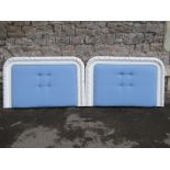 A pair of wall mounted bed head boards, partially buttoned upholstered panels, within painted shaped