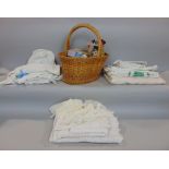 A wicker basket with various cotton reels together with a box of vintage white table linen, waist