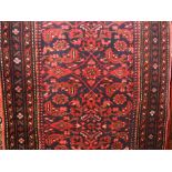Persian full pile runner, decorated with scrolled red and blue foliage upon a red ground, 300 x