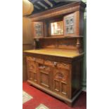 A substantial Victorian pale oak sideboard, the base enclosed by an arrangement of drawers and