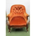 A Victorian drawing room chair with shaped outline, burnt orange upholstered seat and buttoned