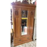 An Edwardian satin walnut single wardrobe, the shaped pediment with carved foliate detail over a