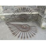A pair of large unusual iron work scrolling brackets, the through rails with spear head finials,
