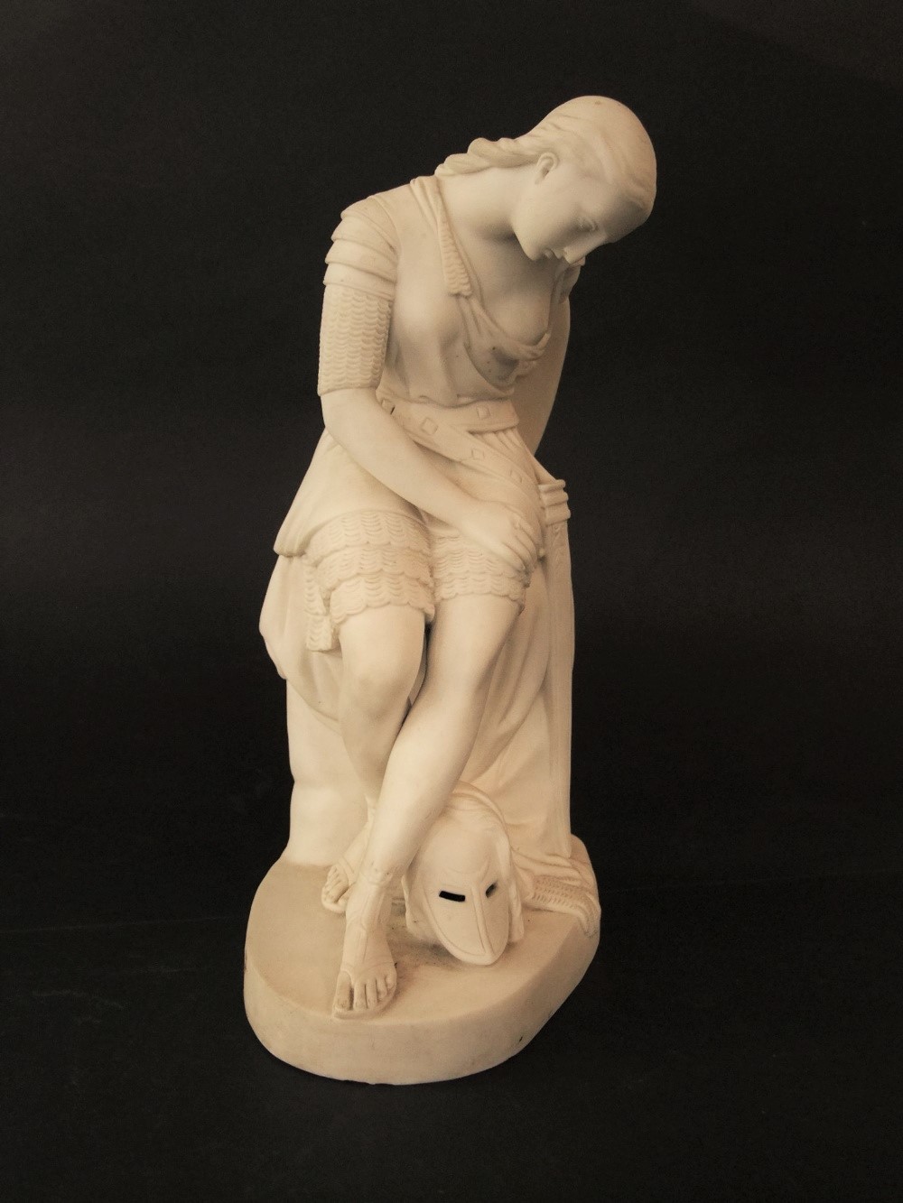 A mid-19th century Parian figure of Joan of Arc seated and wearing her armour, with impressed mark