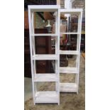 A pair of cream painted wooden floorstanding open shelving units with x framed open framework, 50 cm