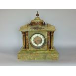 A late 19th century French two train green marble architectural mantel clock with interesting paw