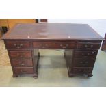 An Edwardian walnut kneehole twin pedestal writing desk in the Georgian style, the rectangular top