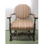 A low open armchair with alternating colourful striped upholstery within a stained beechwood