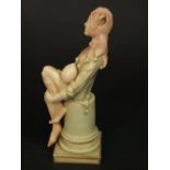 An unusual Doulton Burslem figure of a seated jester, designed by Noke, with printed mark to base,