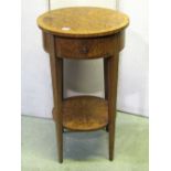 A two tier walnut veneered occasional table of circular form with decorative sunburst detail, frieze