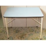 A small 1950s kitchen table of rectangular form with rounded corners and light blue formica top