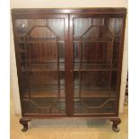 A small Georgian style freestanding side cabinet enclosed by a pair of astragal glazed panelled