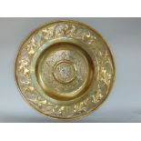 Good quality continental cast brass charger with central silvered crest, with scrolled leaf and