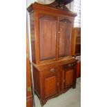 An Edwardian library bookcase, the lower section enclosed by two panelled doors and two frieze