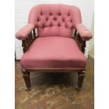 A late Edwardian tub chair with upholstered seat and arched button back, raised on square cut and