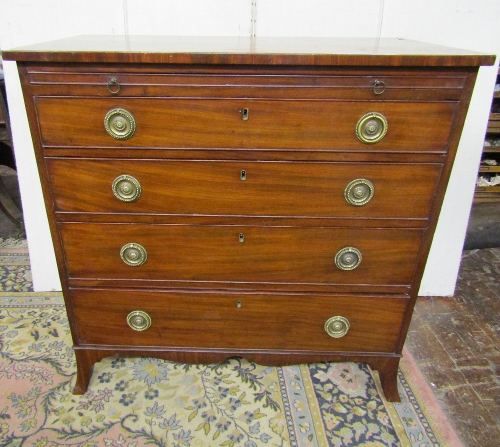 A small Georgian mahogany chest of four long graduated drawers together with a brush slide, shaped