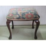 A 19th century stool of rectangular form with serpentine outline, upholstered seat, cabriole legs,