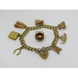 9ct double curb link charm bracelet with heart padlock clasp, hung with seven charms to include