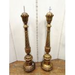 A pair of continental gilded timber pricket candlesticks with tapering and spiral column detail,