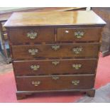 A Georgian oak crossbanded countrymade chest of three long and two short drawers on bracket