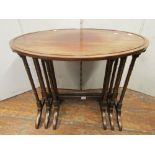 A nest of three graduated occasional tables in mahogany, the oval tops raised on slender supports,