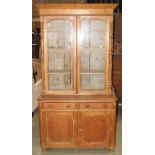 A Victorian stripped pine washstand or low side cupboard enclosed by a pair of geometric moulded