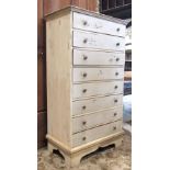 A hardwood bedroom chest of eight long drawers with button handles and all over painted and