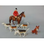 A collection of Beswick wares comprising a huntsman on a brown horse, four hounds and a seated fox