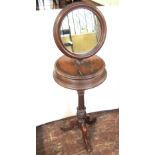 A Victorian walnut shaving stand, the circular mirror raised on an adjustable column with central