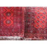 Two similar Bokhara type prayer mats/small rugs, both with typical geometric decoration upon a red
