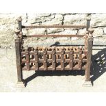 A cast iron fire basket of rectangular form with urn shaped finials