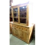 A stripped and waxed pine kitchen dresser, the base enclosed by three rectangular moulded panelled