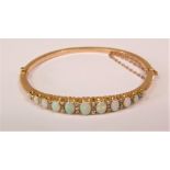 Edwardian opal and diamond bangle set with eleven graduated oval opals interspersed with diamonds,