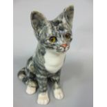 A Winstanley model of a seated grey and white cat with yellow glass eyes and painted mark to base,