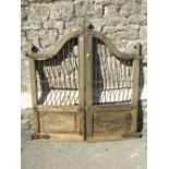 A pair of small 19th century weathered hardwood gates of arched form with fielded panels and iron