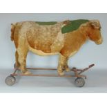 An old child's straw filled pull along toy bull/cow raised on an iron framework (possibly Steiff) (