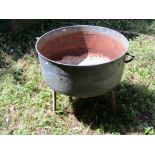 A large 19th century cast iron cauldron, later adapted as a planter and raised on an iron tripod