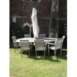 A weathered contemporary teak Cotswold Collection drawleaf garden table with D shaped ends and
