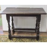 18th century oak cottage table, the plank top raised on four turned supports united by moulded