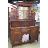 An Edwardian walnut mirror back sideboard enclosed by an arrangement of cupboards and drawers with