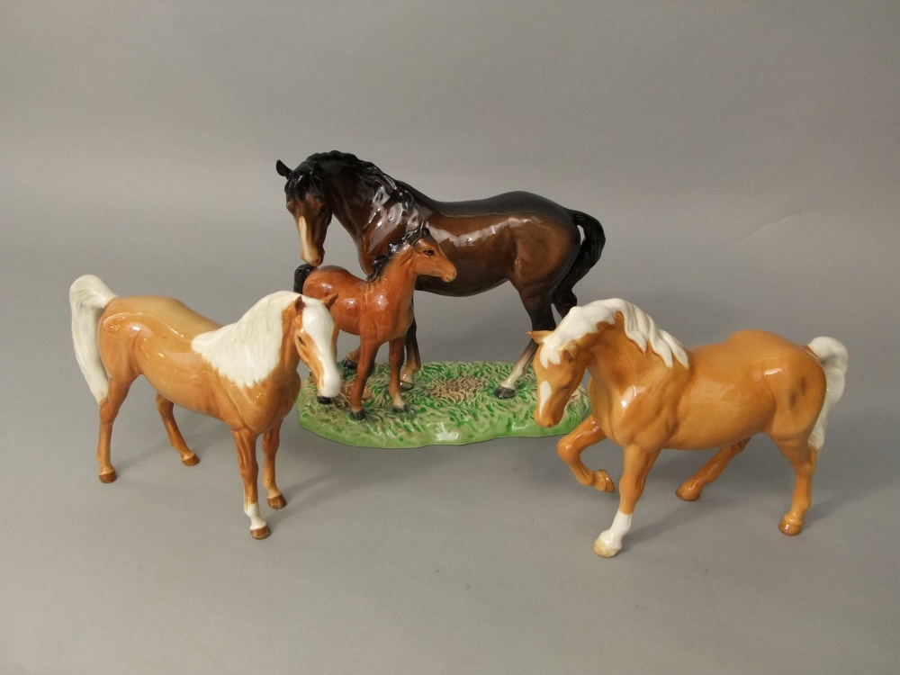 A Beswick group of a male and a foal raised on a moulded simulated grass base, together with two