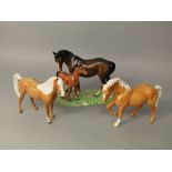 A Beswick group of a male and a foal raised on a moulded simulated grass base, together with two
